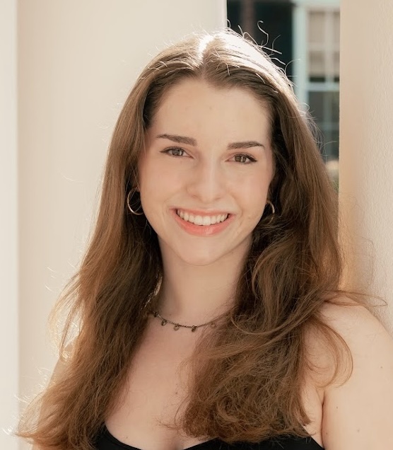 woman in a dress with long brown hair smiling at camera