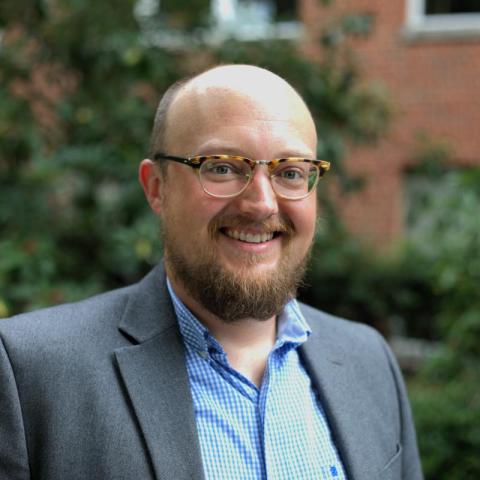 Man with beard and glasses wearing a suit